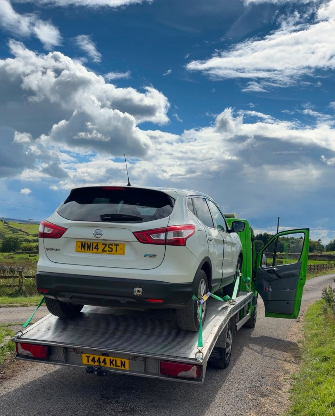 KLN recovery vehicle carrying a car on a rural road